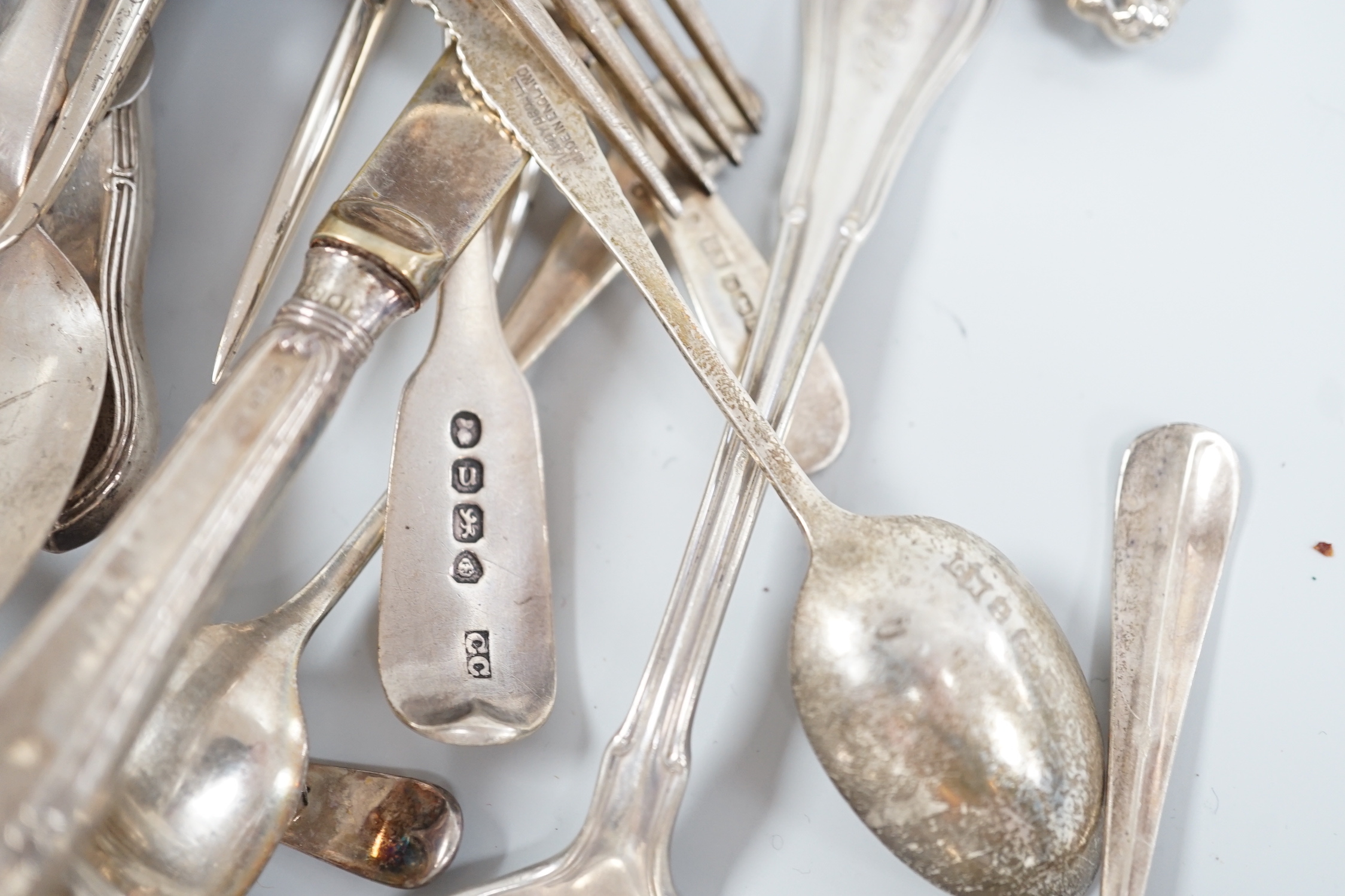 Sundry silver and white metal flatware including a George III silver Old English pattern basting spoon, London, 1782, teaspoons, condiments spoons, sifter spoon, caddy spoon etc.